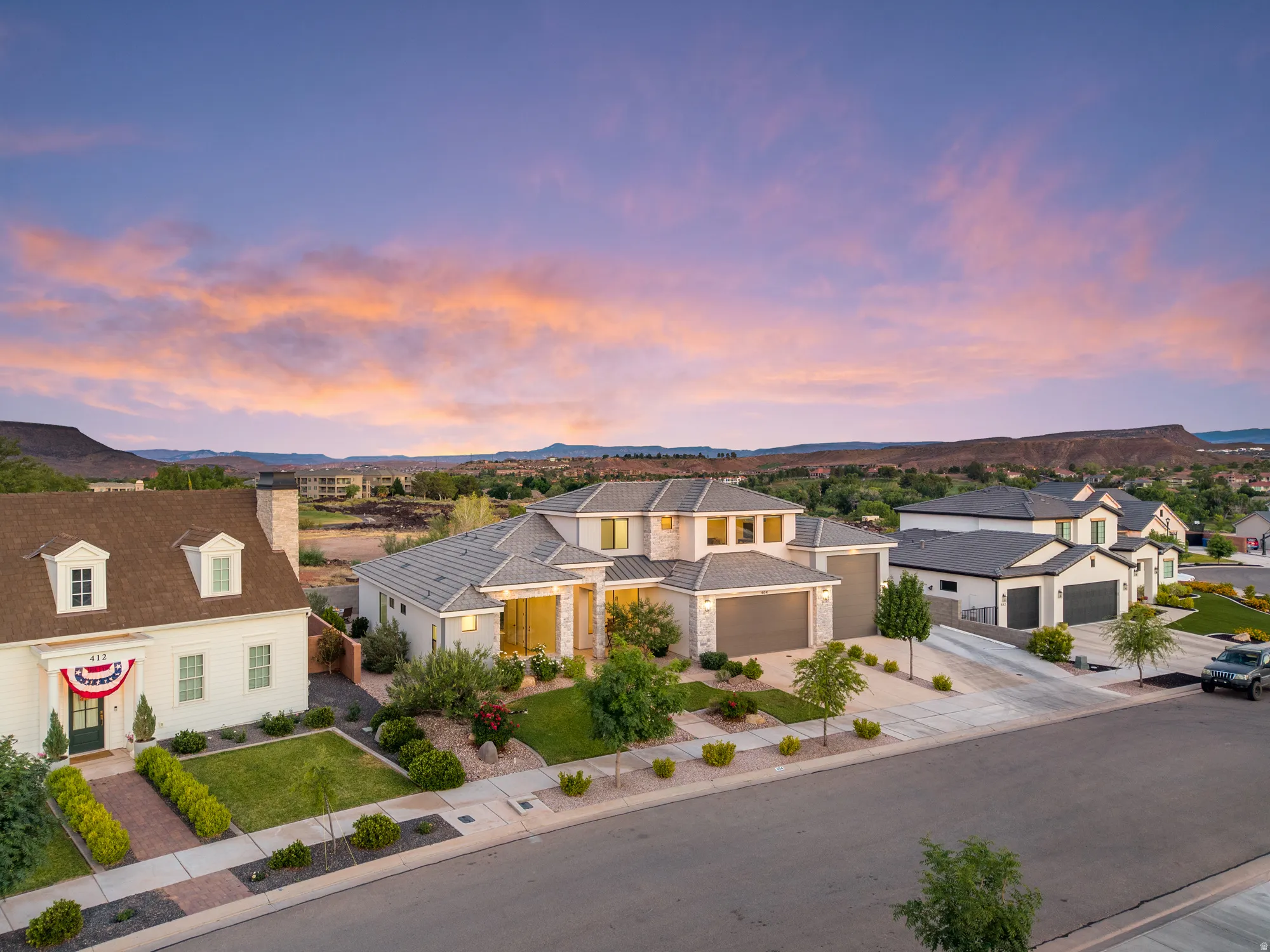 Modern architectural style with a light-toned exterior, stone accents, and a grey tile roof