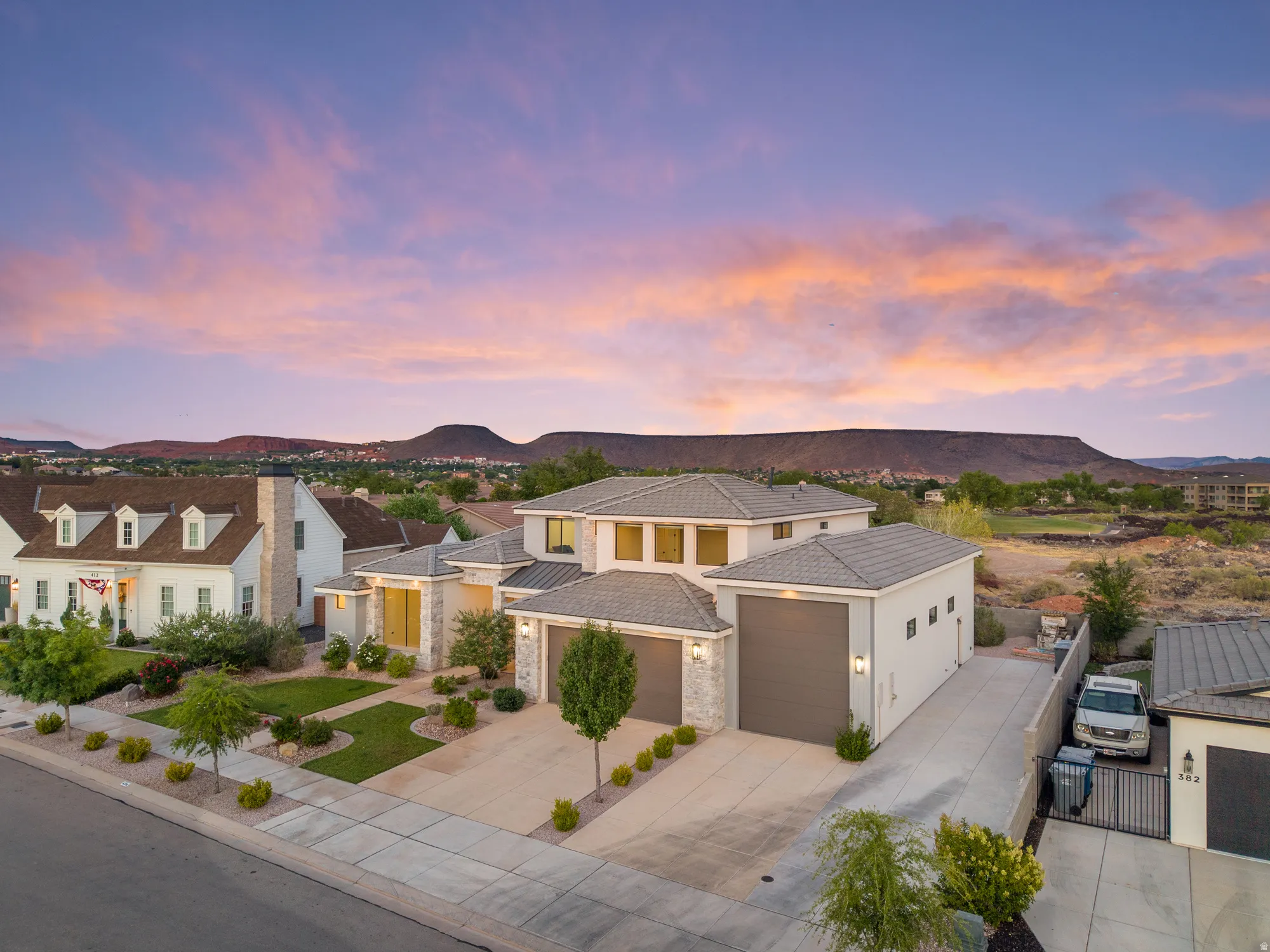 Contemporary residence with a multi-level design, featuring a light-colored stucco and stone facade
