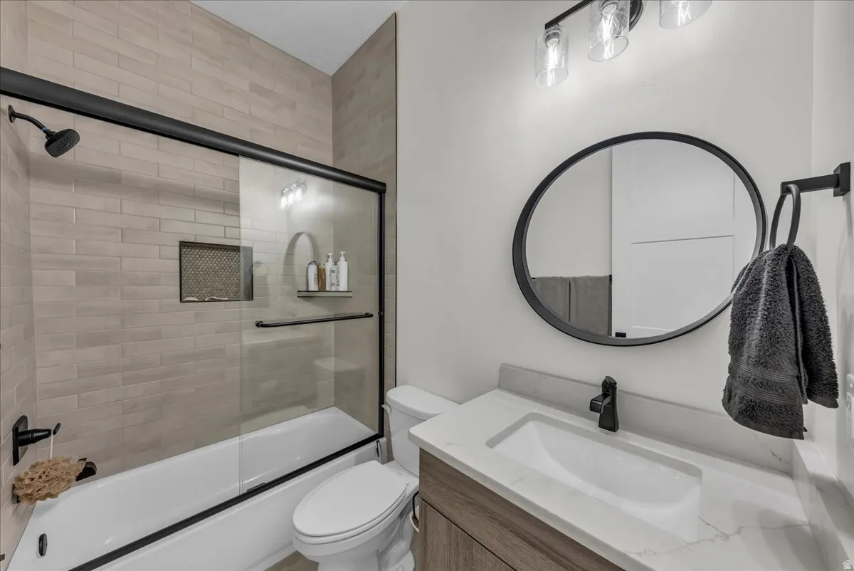 Bathroom with vanity and enclosed tub / shower combo