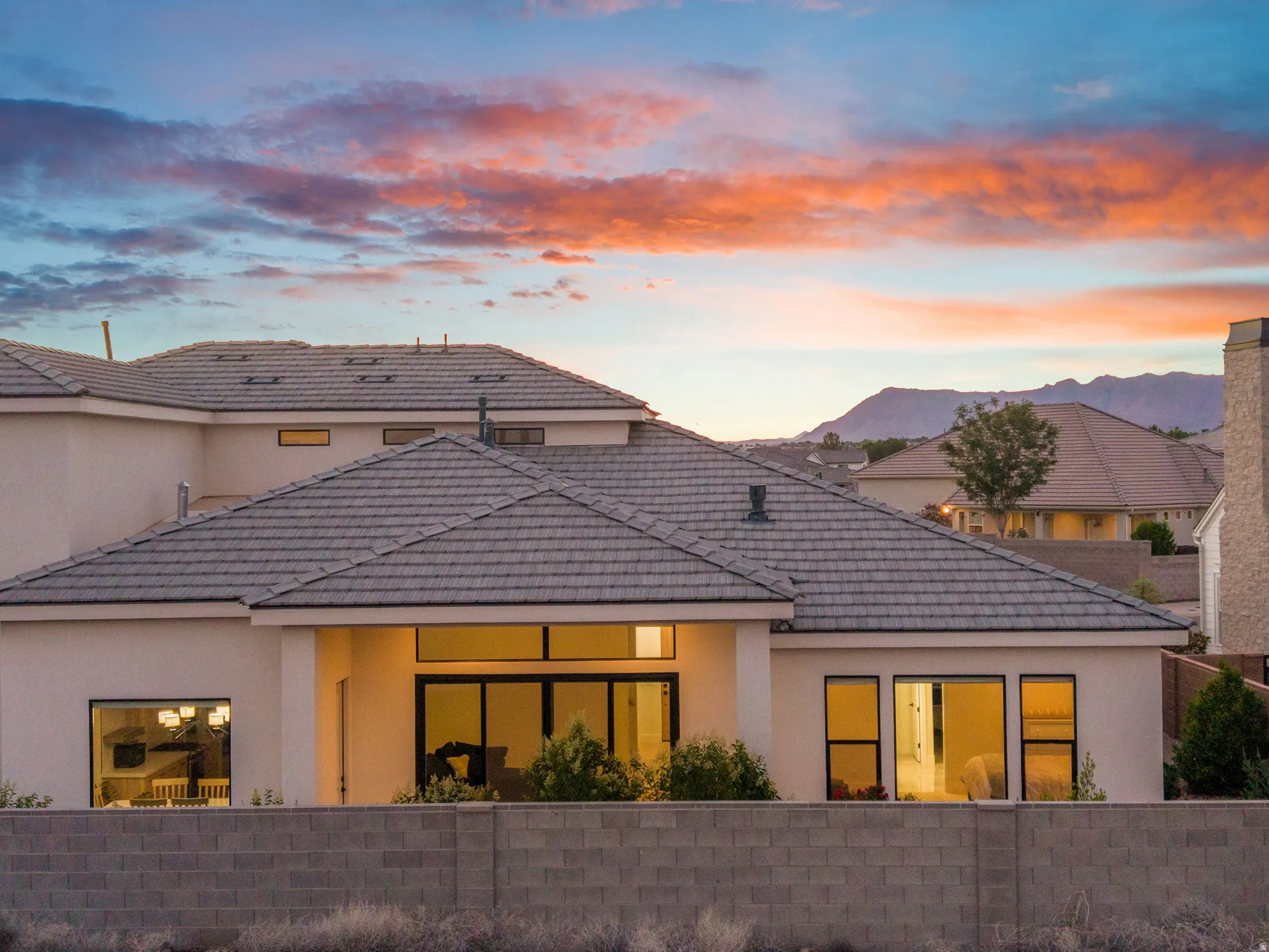 Stucco exterior residence with a tiled roof and expansive windows