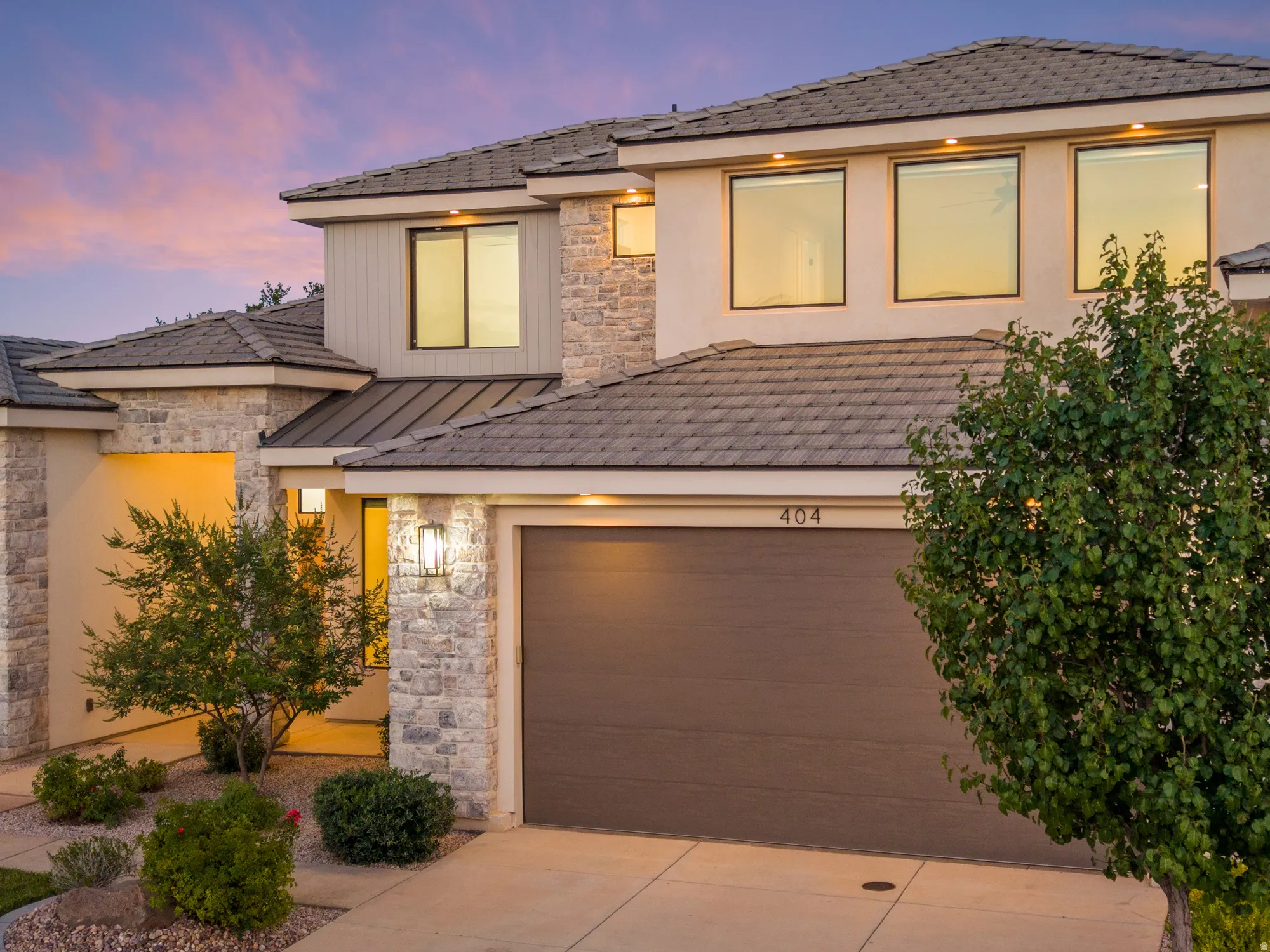 Contemporary two-story exterior featuring a mix of stucco and stone veneer finishes