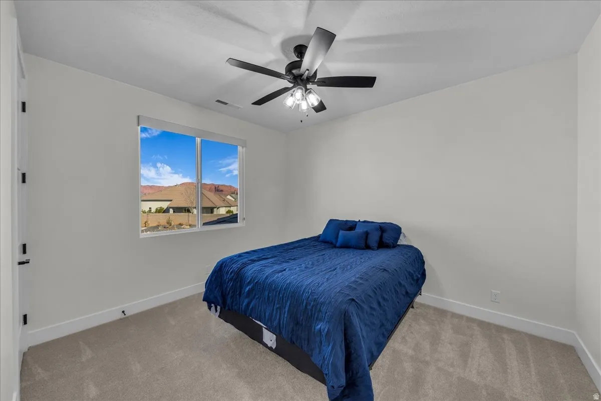 Bedroom with light carpet and ceiling fan