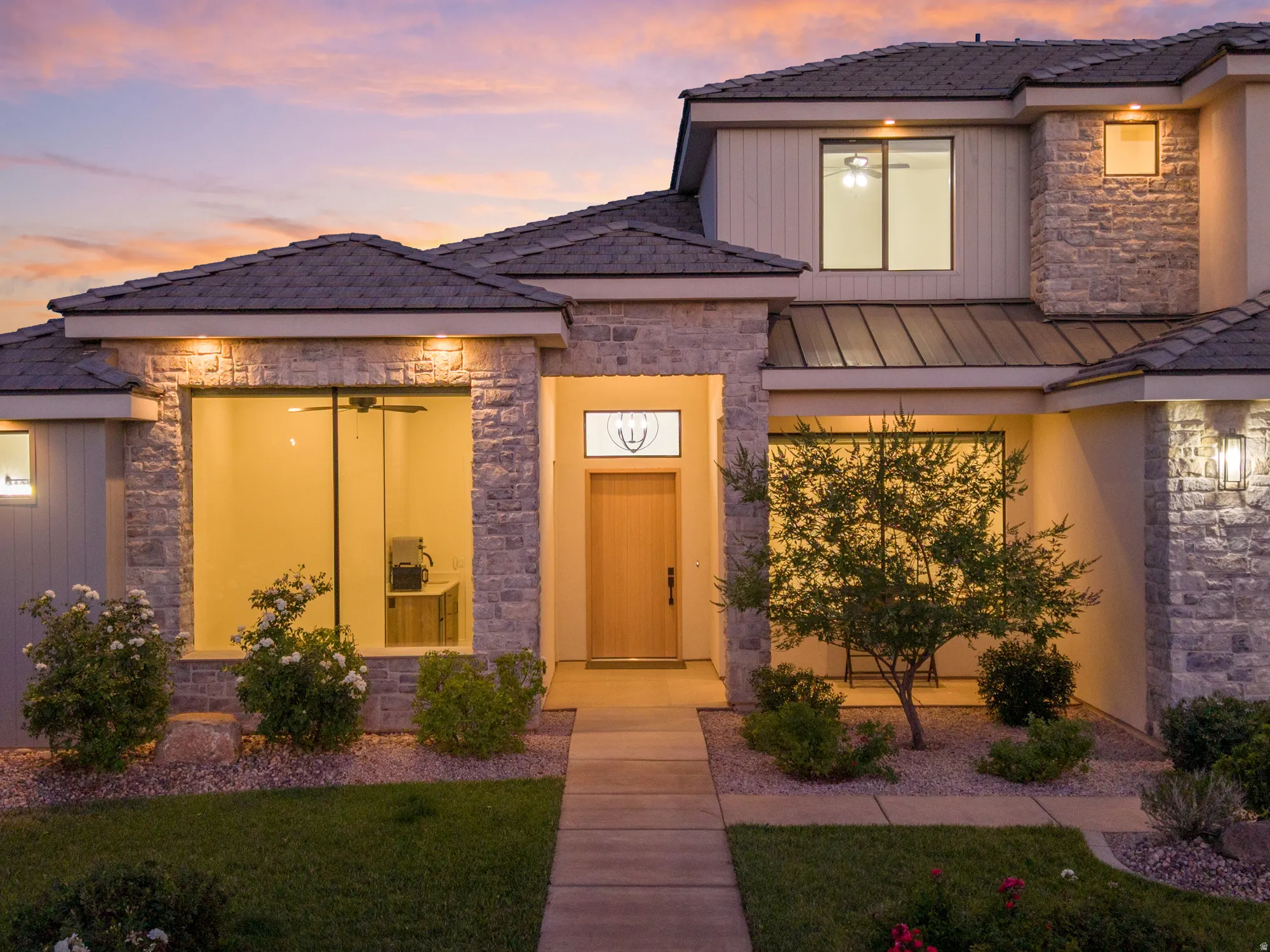 Modern two-story residence featuring a stone and siding exterior