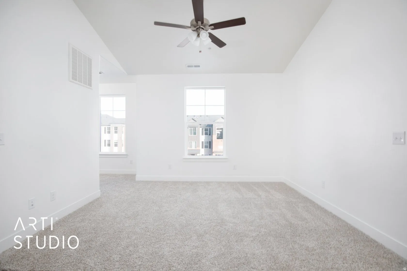 Carpeted empty room featuring ceiling fan and lofted ceiling