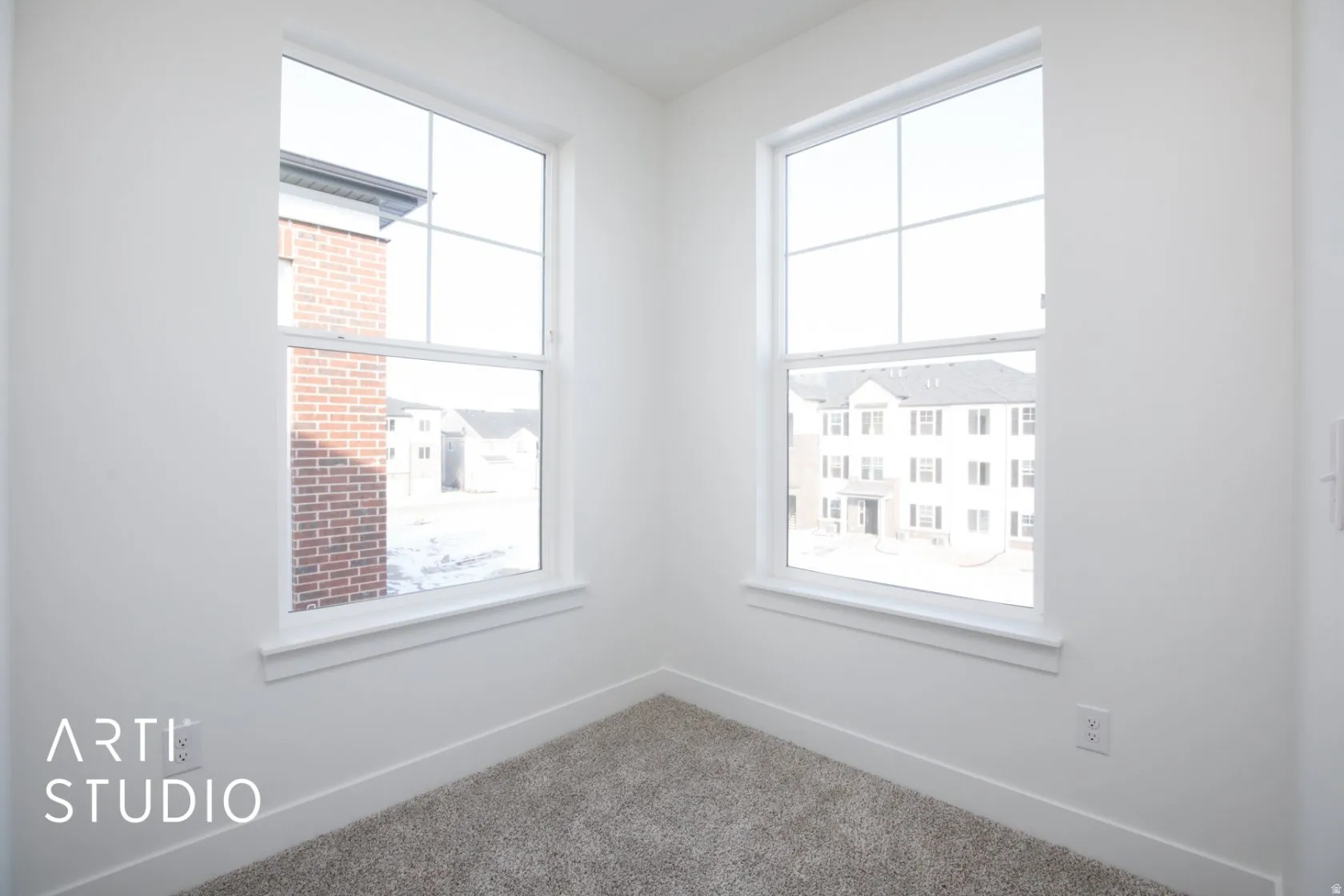 Carpeted spare room featuring baseboards