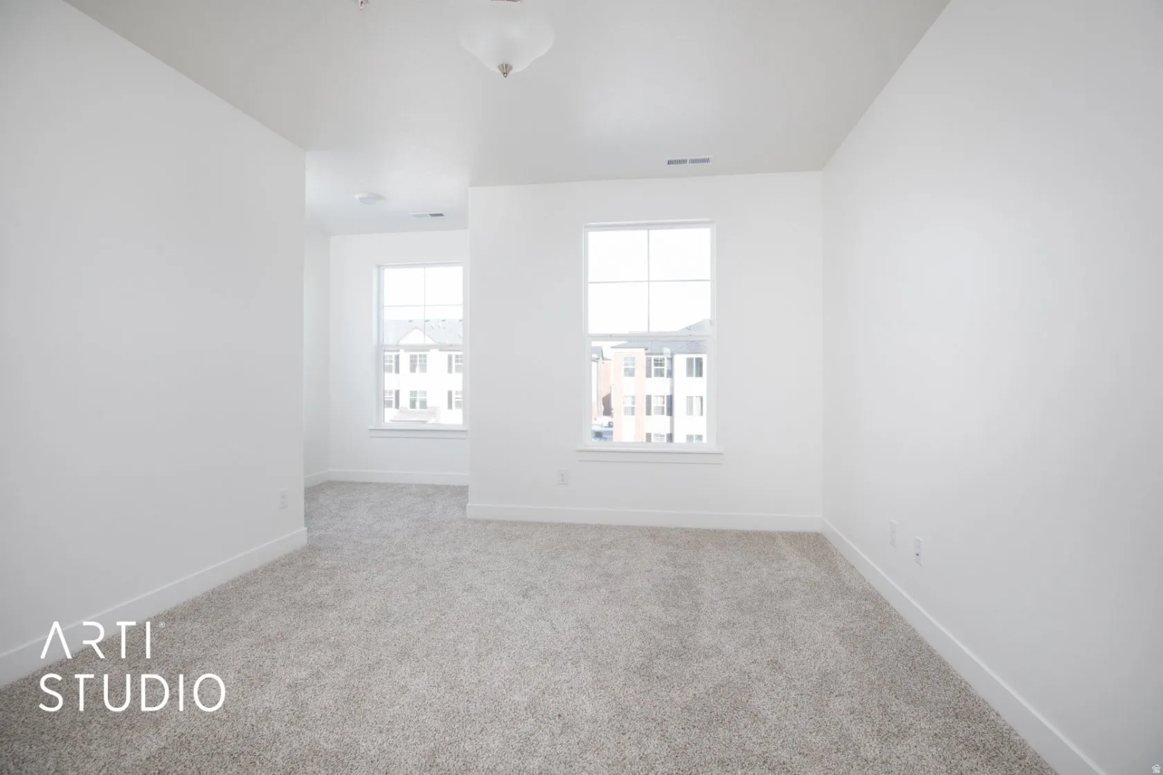 Empty room featuring light carpet and baseboards