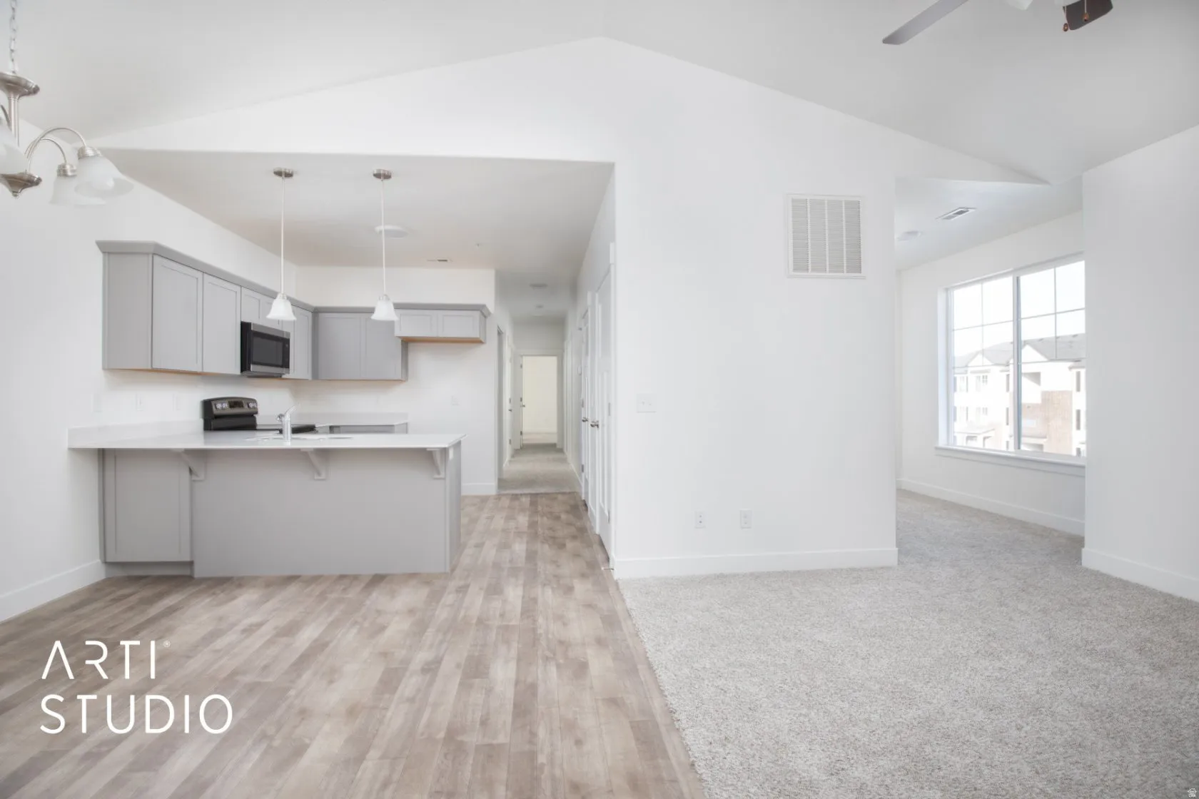 Kitchen featuring gray cabinetry, a peninsula, a breakfast bar, light wood-type flooring, and open floor plan
