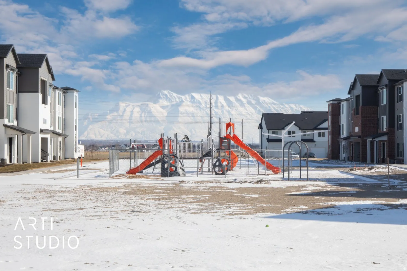 Snow covered playground with a residential view