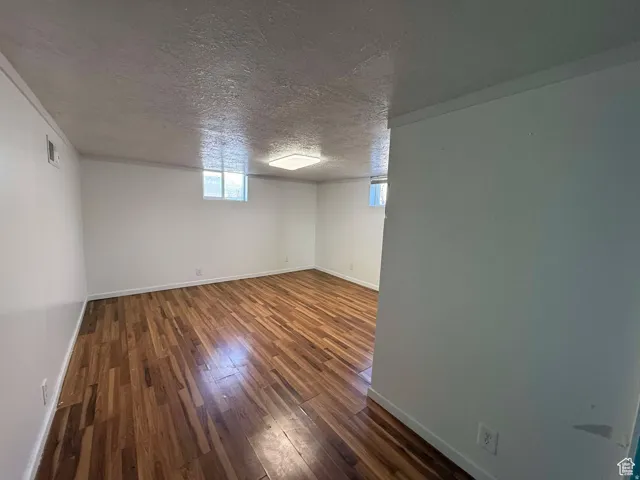 Basement featuring dark wood finished floors and a textured ceiling