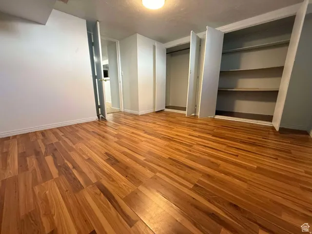 Unfurnished bedroom featuring light wood-style floors and multiple closets