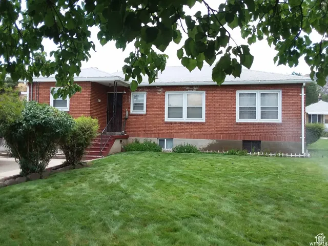 Single story home featuring a front yard and brick siding