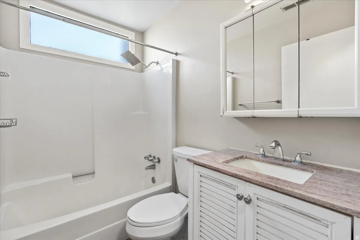 Bathroom with vanity and bathtub / shower combination