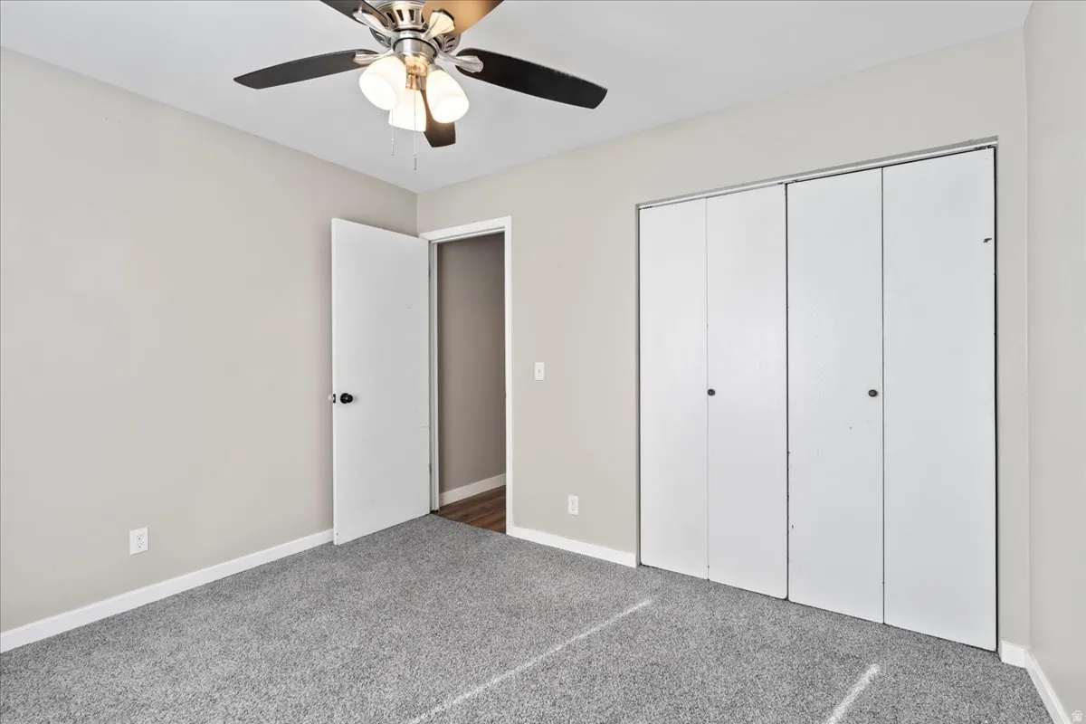 Unfurnished bedroom with carpet flooring, a closet, and a ceiling fan