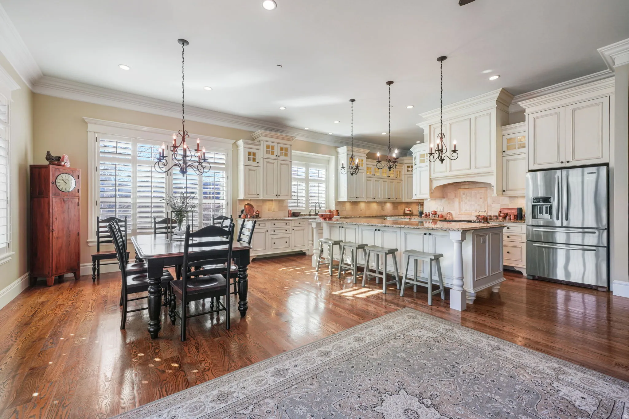 Dining space with hanging lights, crown molding, and dark wood finished floors