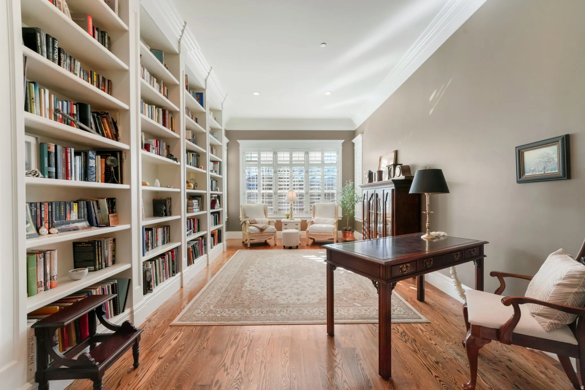 Office space with crown molding and light wood-type flooring