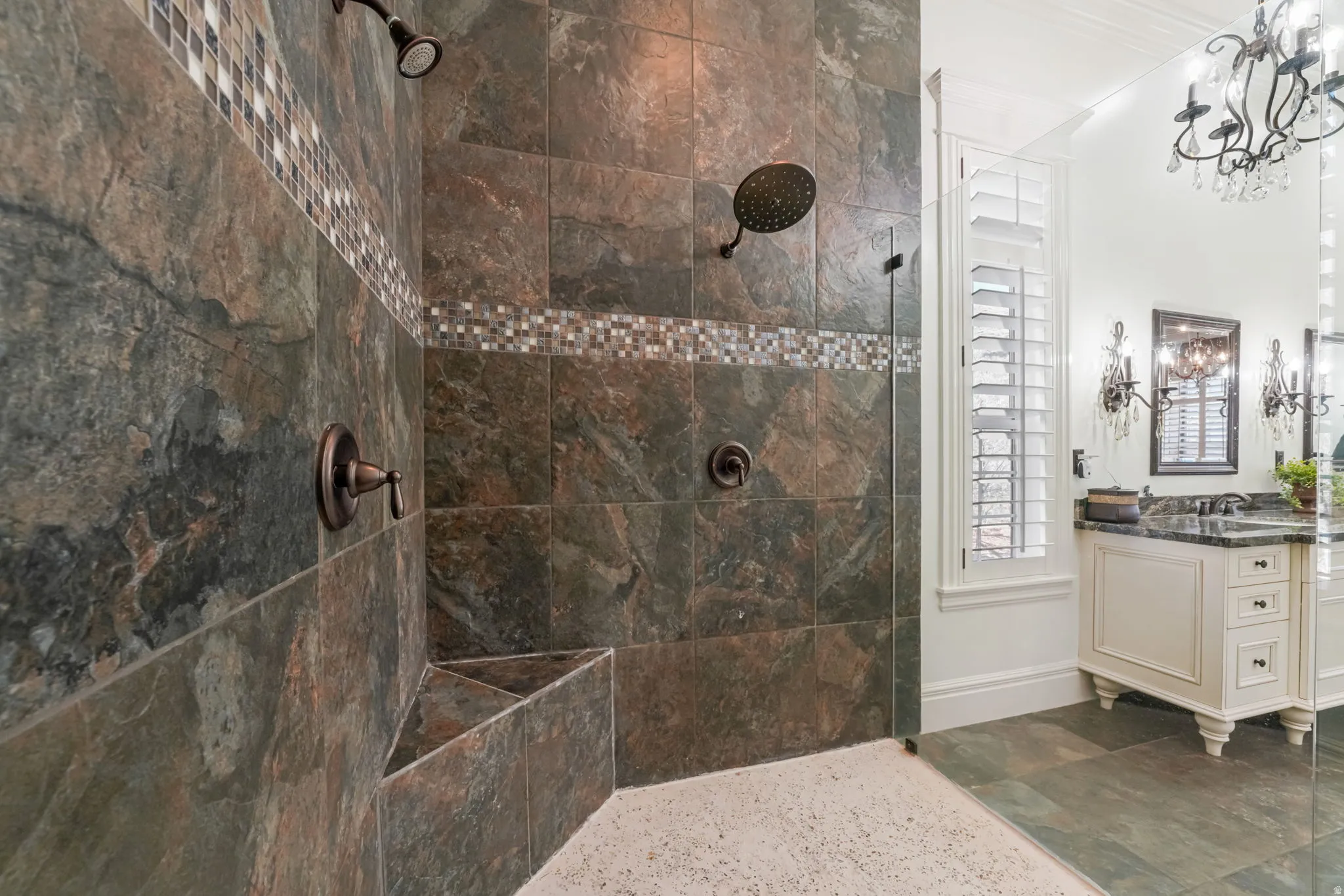 Full bath featuring a walk in shower, dark stone finish flooring, and vanity