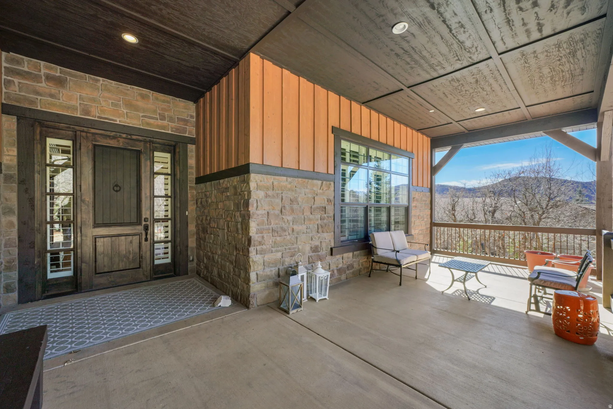 View of exterior entry featuring stone siding, board and batten siding, and a mountain view