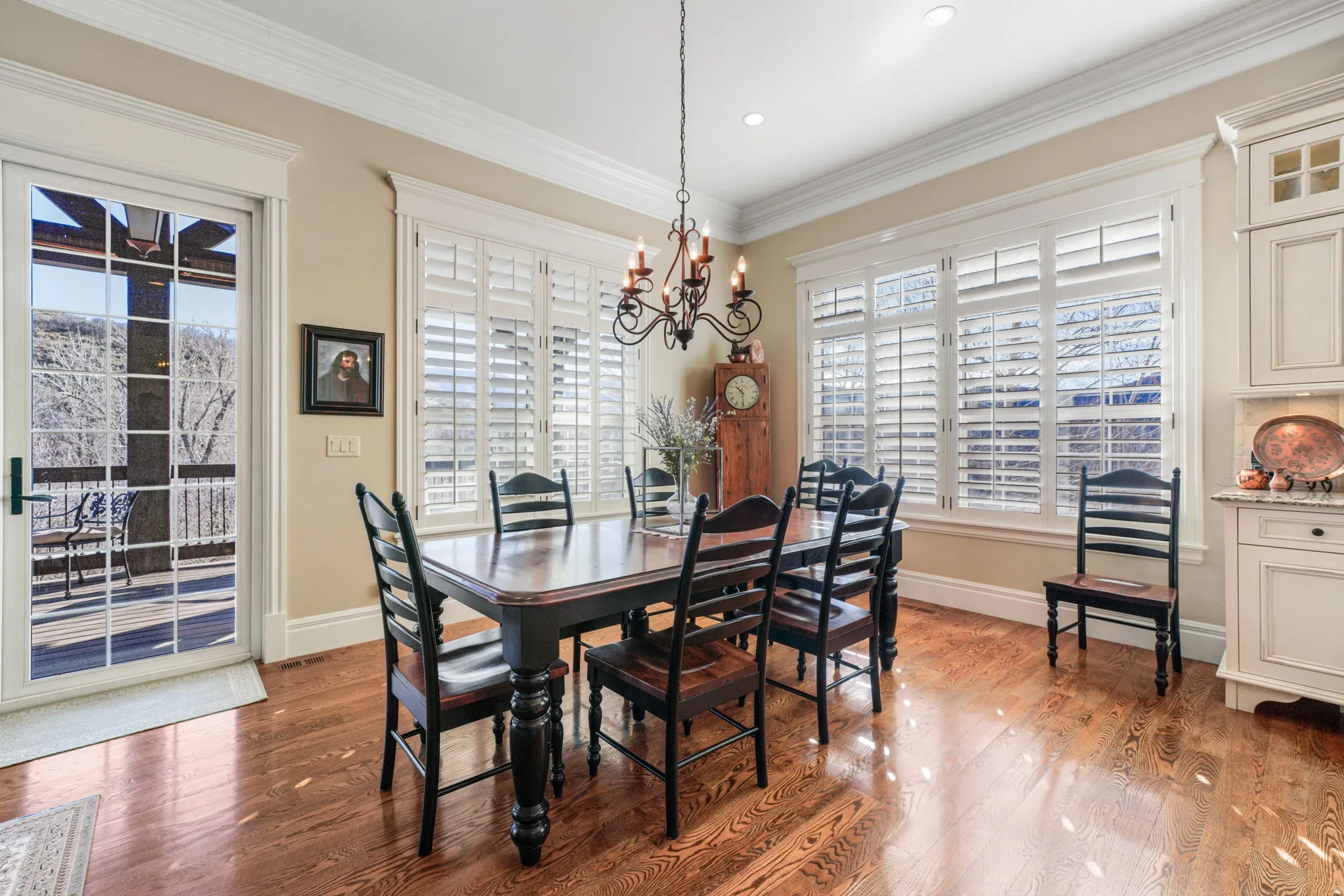 Dining area with hanging lights, light wood-type flooring, and ornamental molding