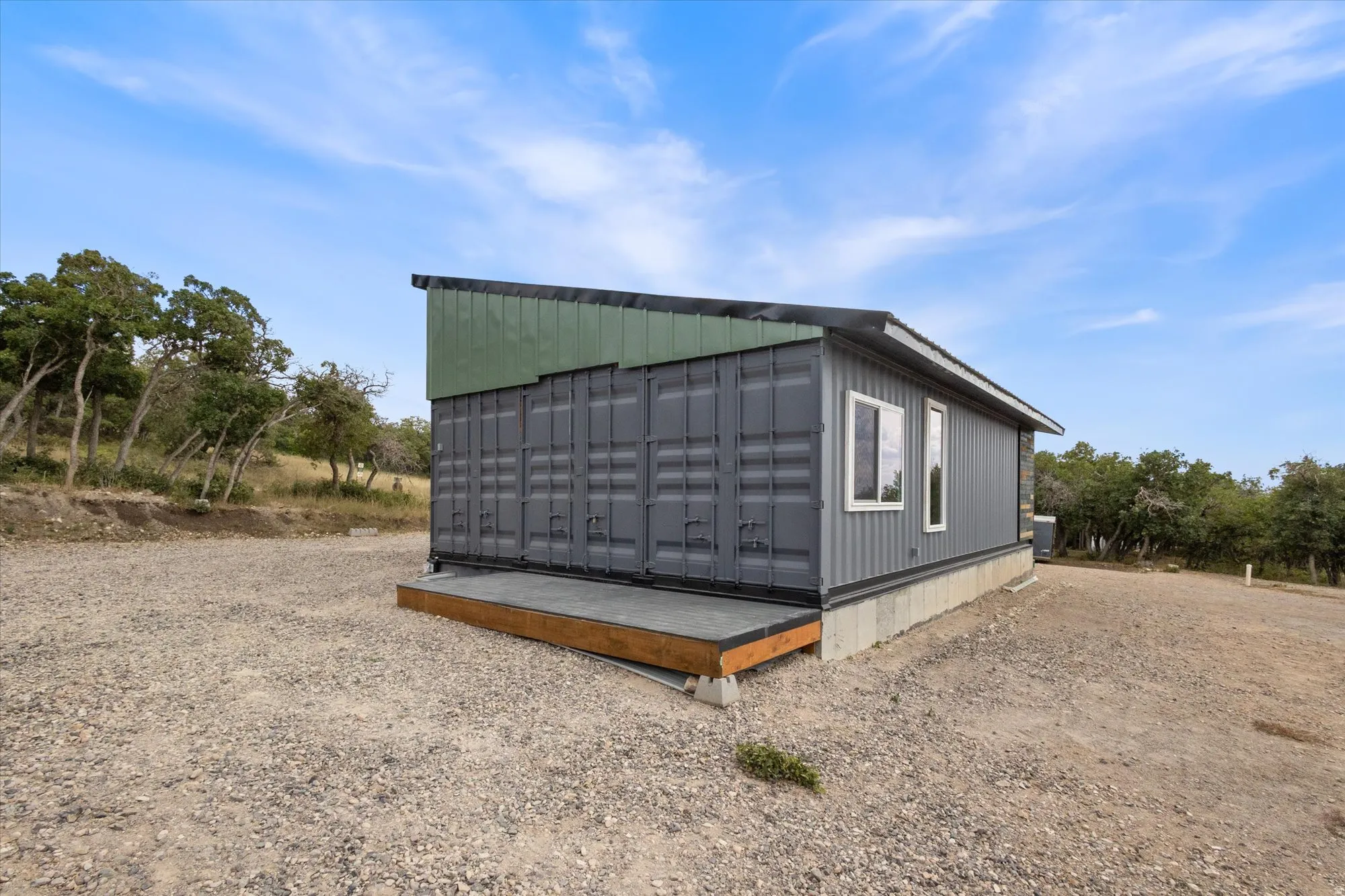 View of property exterior with mail area and a wooden deck