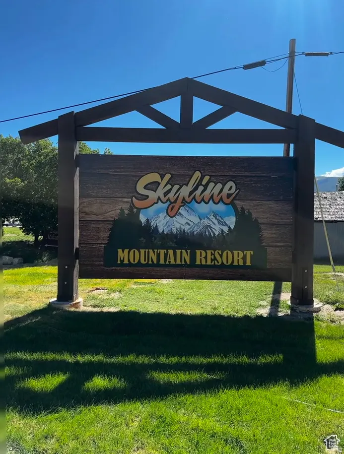 Community / neighborhood sign featuring a lawn