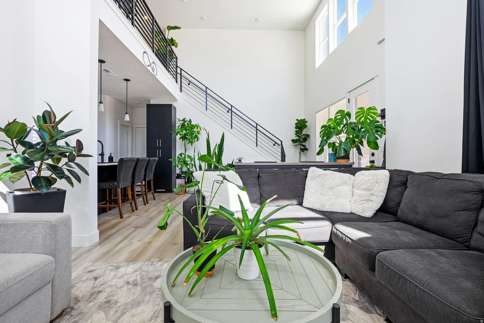Living room with a high ceiling and light wood-type flooring