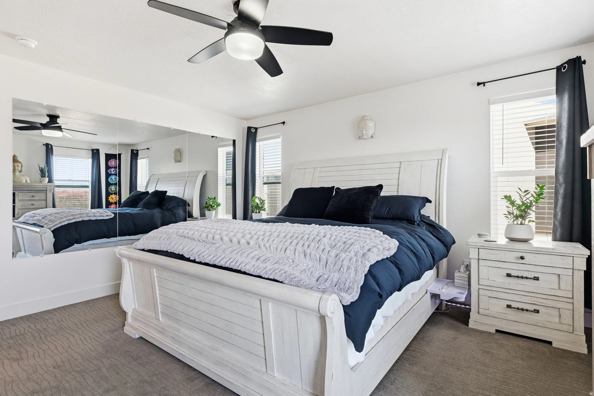 Bedroom featuring a ceiling fan and dark colored carpet