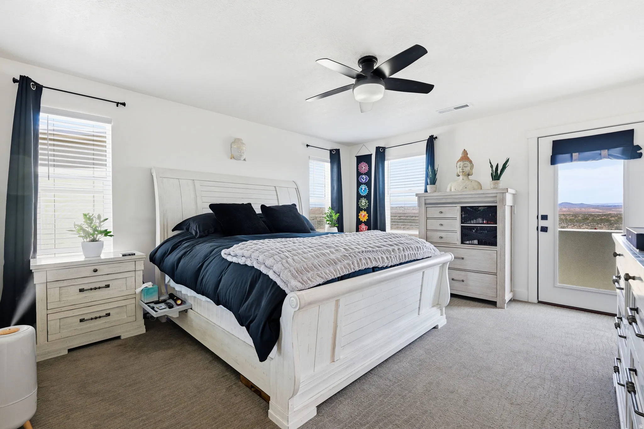 Bedroom with dark colored carpet, access to exterior, and a ceiling fan