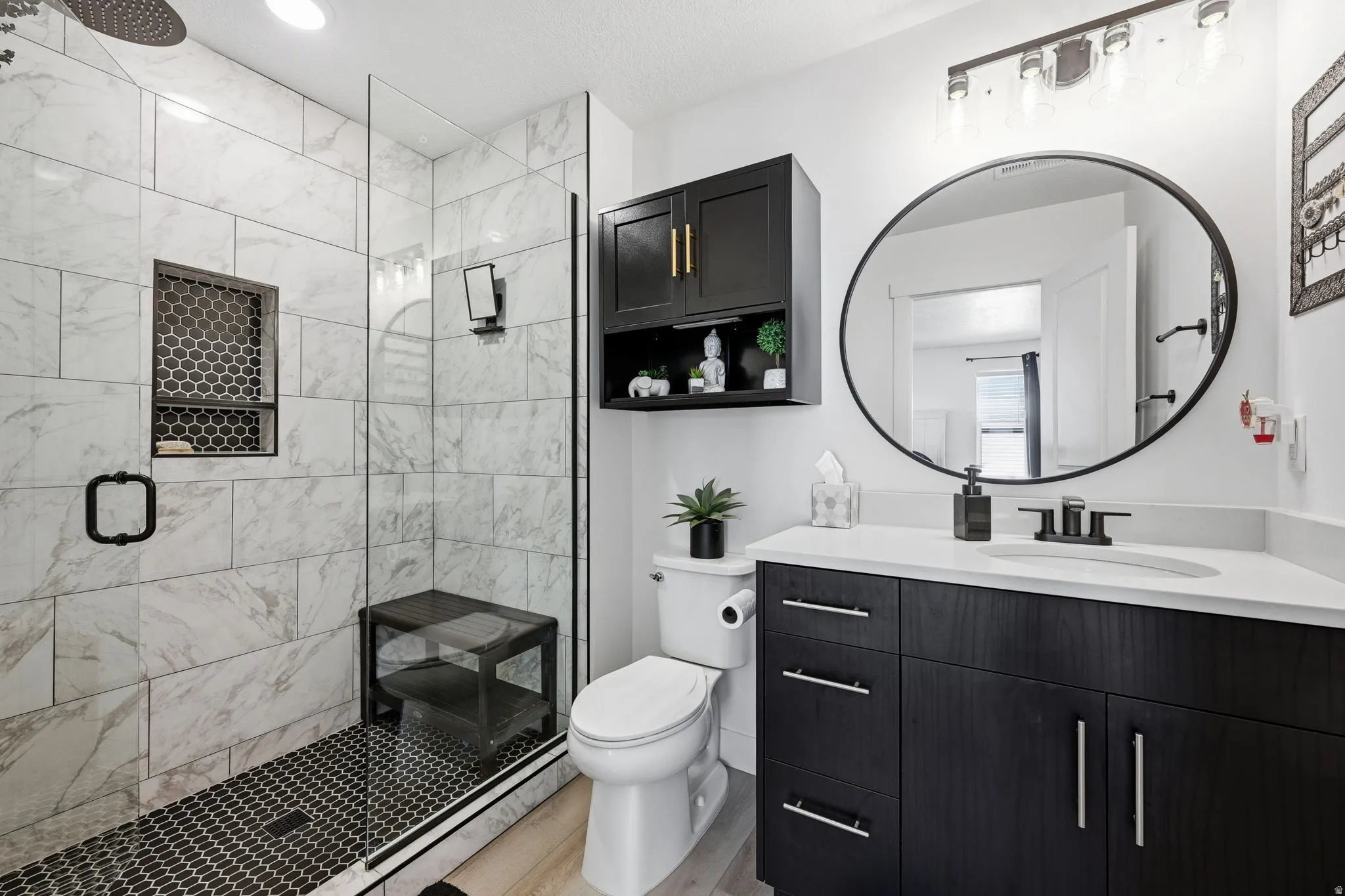 Full bathroom featuring vanity, a shower stall, and light wood-type flooring