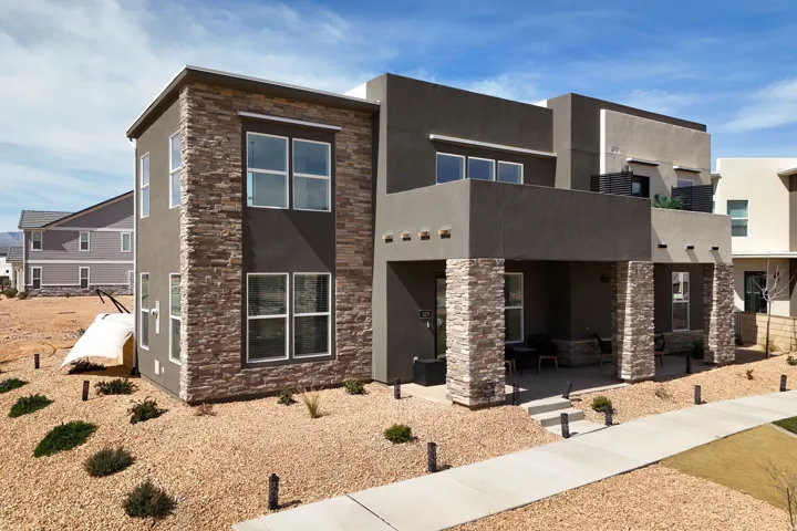 Contemporary house with stone siding, stucco siding, and a patio