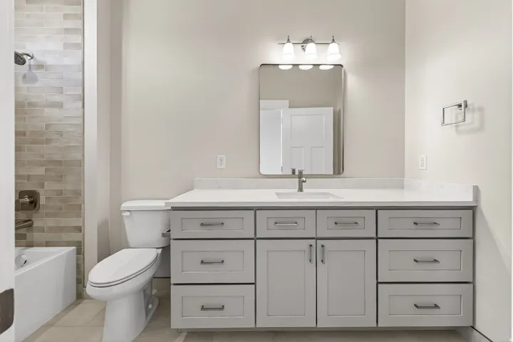 Bathroom with vanity, tub / shower combination, and light tile patterned flooring