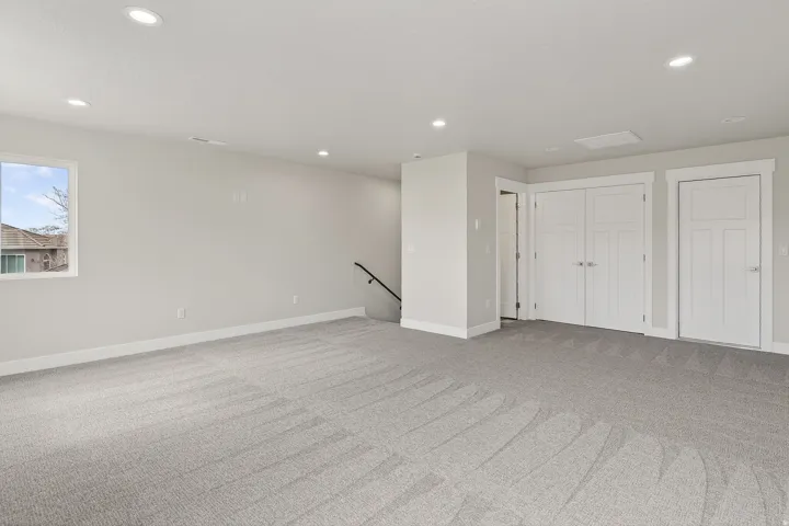 Below grade area with light colored carpet and recessed lighting