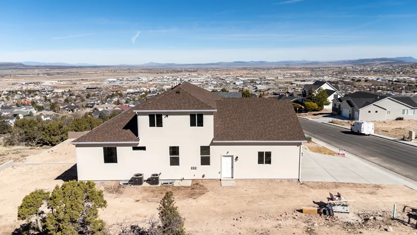 Rear view of house with a shingled roof, stucco siding, a residential view, and a mountain view