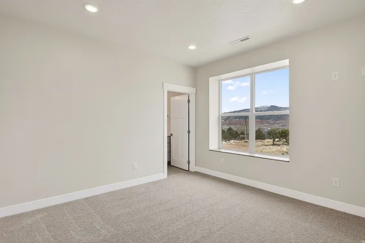 Empty room featuring a mountain view, light carpet, and recessed lighting