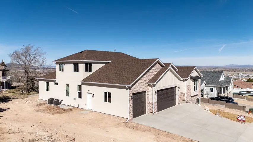 View of front of house with roof with shingles, concrete driveway, a garage, stucco siding, and a residential view