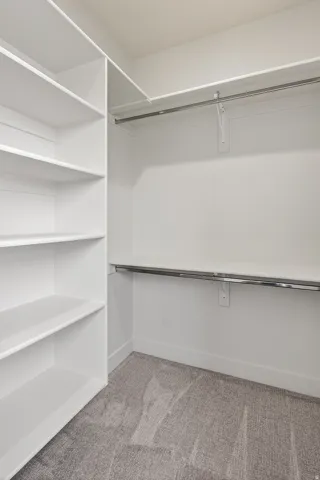 Walk in closet with light carpet