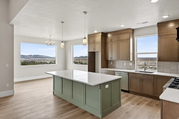 Kitchen with backsplash, a kitchen island, green cabinetry, a mountain view, and dishwasher