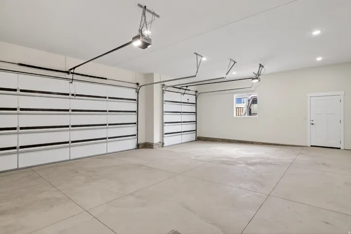 Garage featuring baseboards and a garage door opener