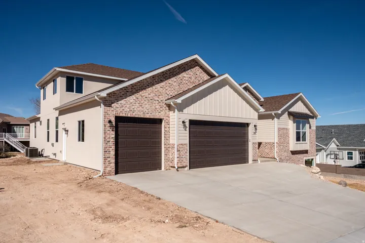View of front of property with a garage, driveway, and board and batten siding