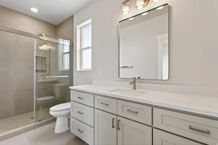 Full bath with vanity, a stall shower, and light tile patterned flooring