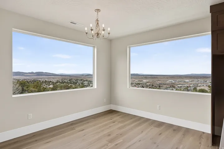 Unfurnished room featuring a mountain view, hanging lights, and light wood-type flooring