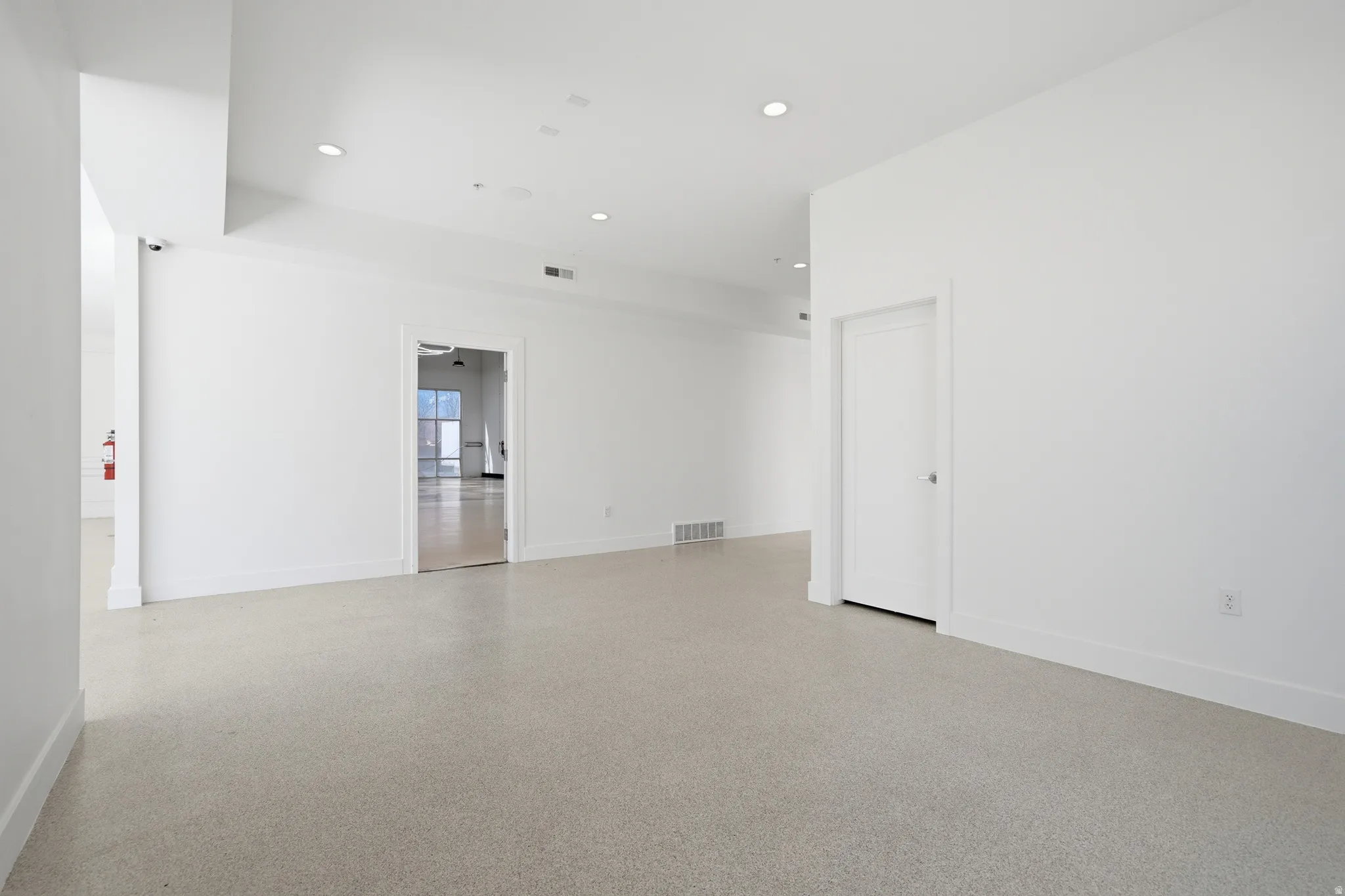 Unfurnished room featuring epoxy flooring and recessed lighting