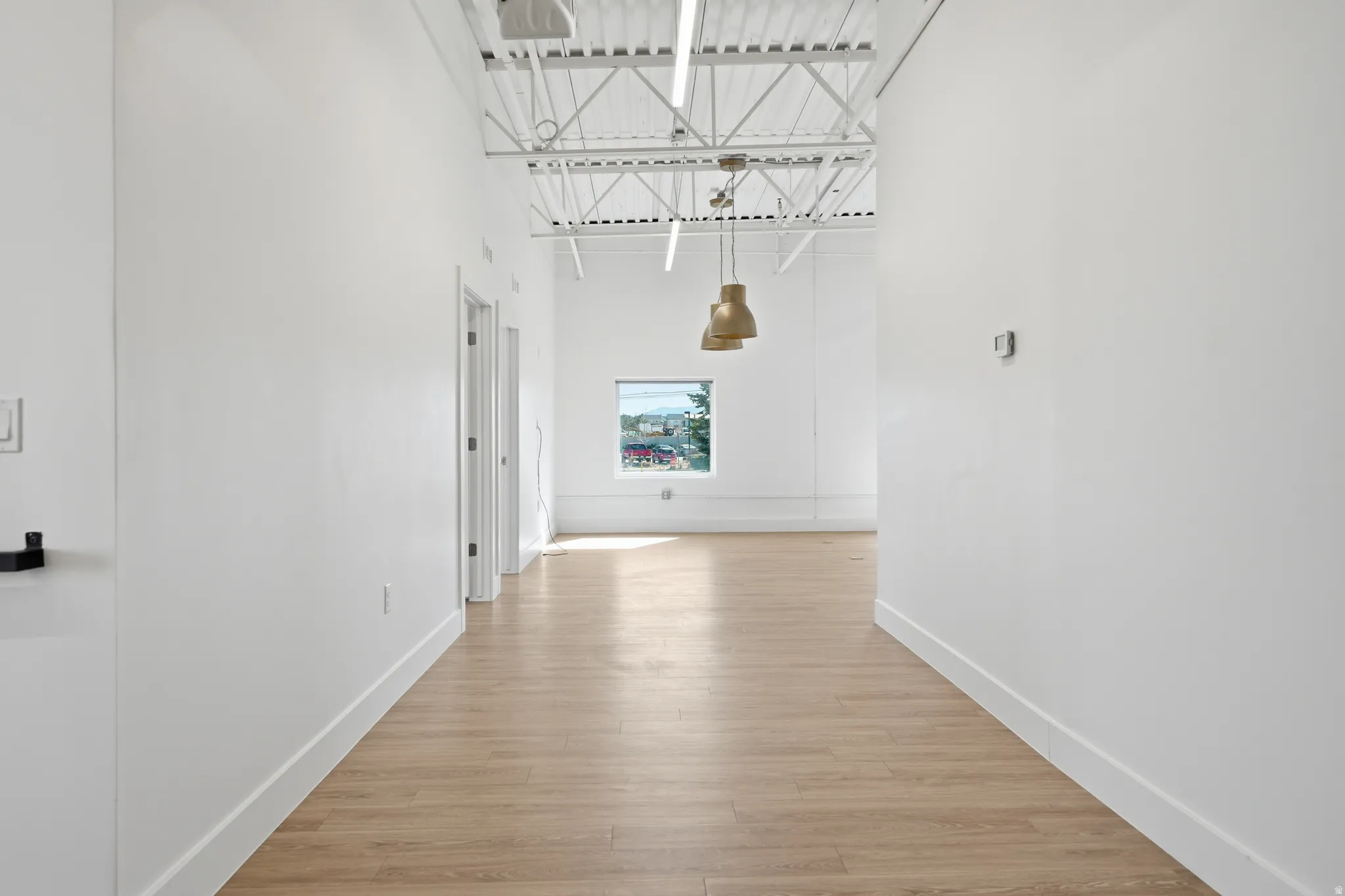 Hall featuring a high ceiling and light wood-style flooring