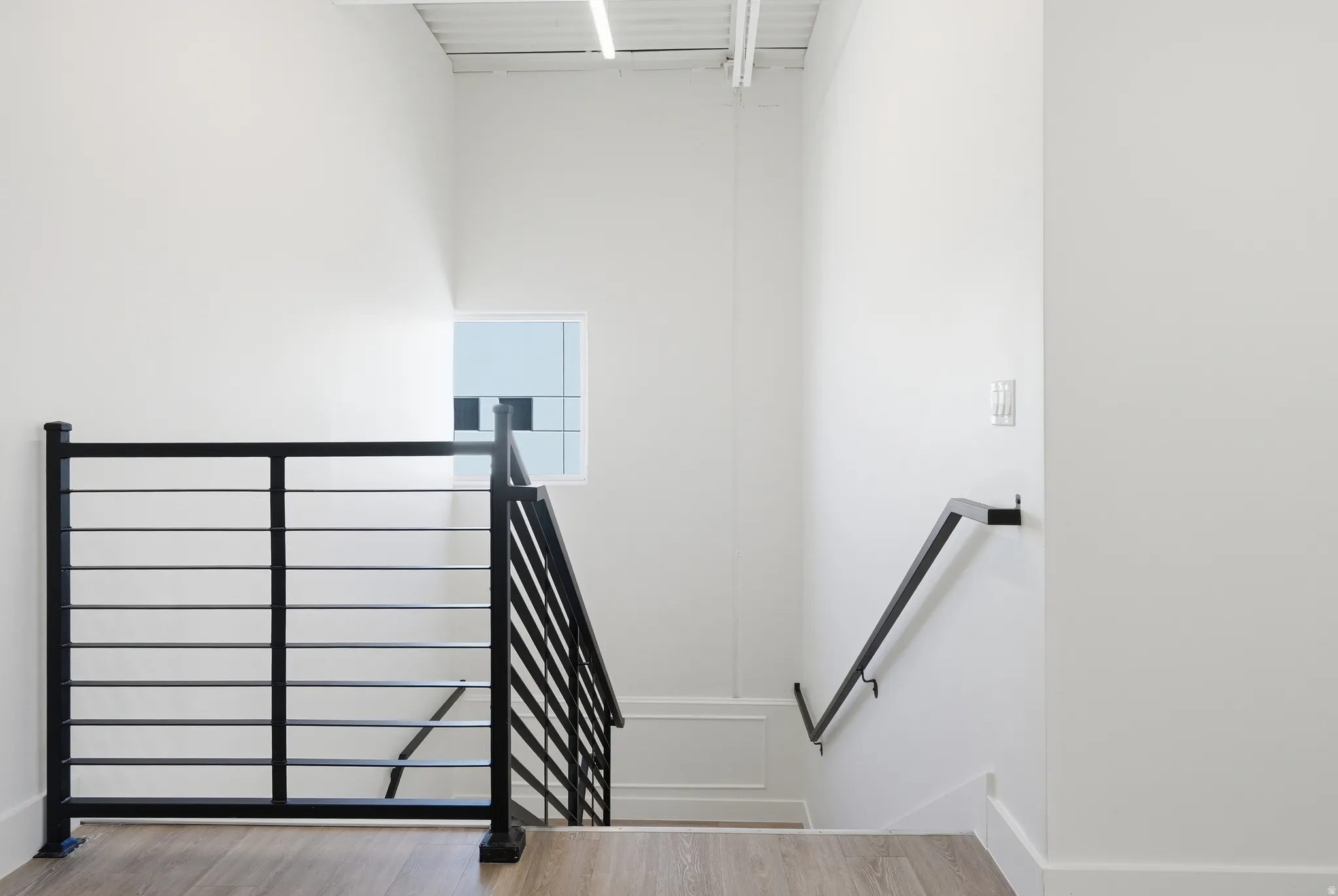 Stairway featuring wood finished floors