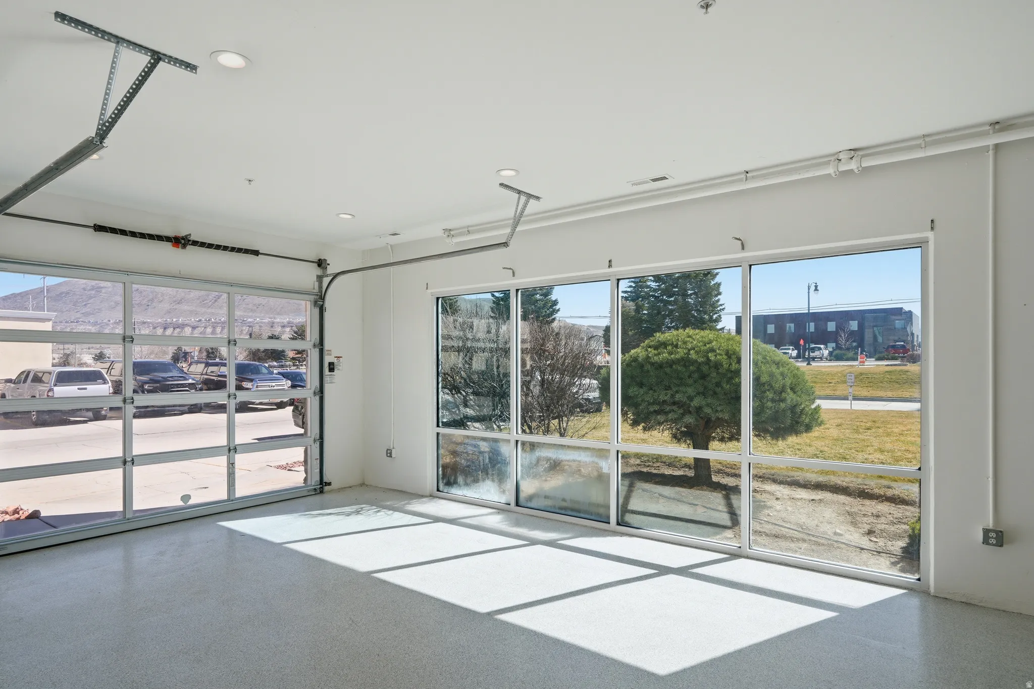 Unfurnished room with epoxy flooring and recessed lighting
