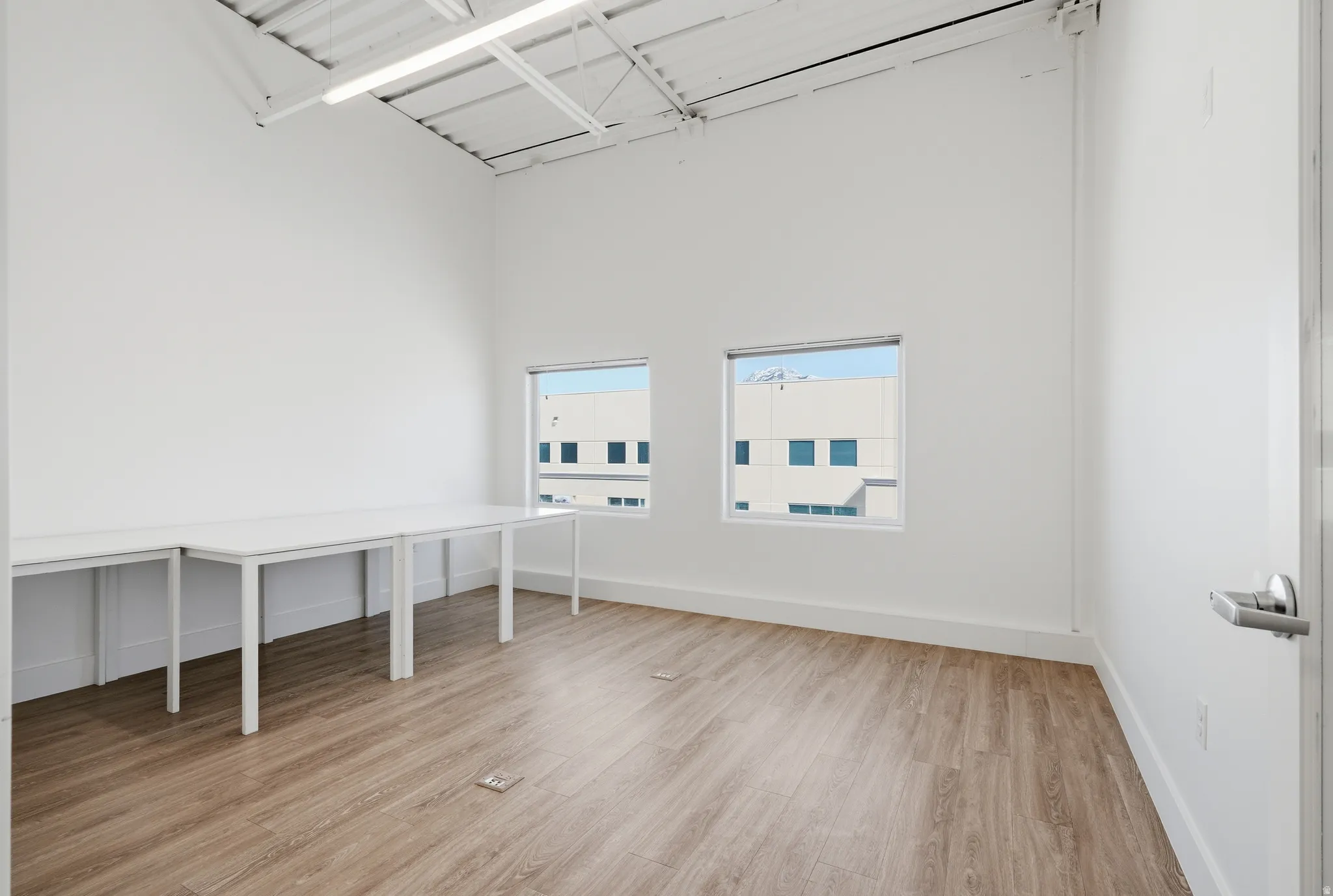 Interior space featuring light wood finished floors and a high ceiling