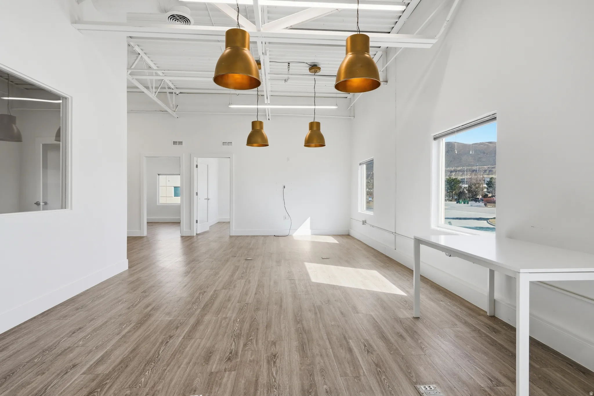 Unfurnished living room with a high ceiling and light wood-style flooring