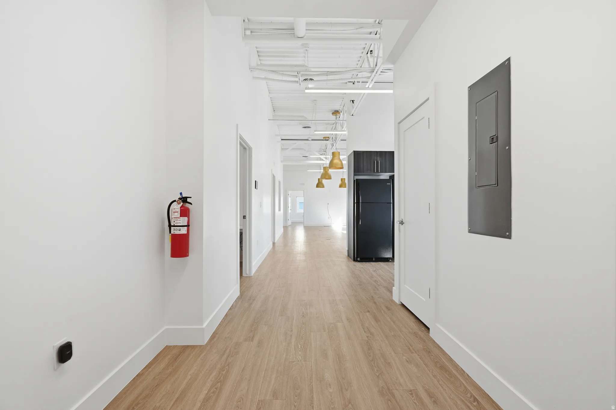 Corridor featuring light wood-style flooring and electric panel