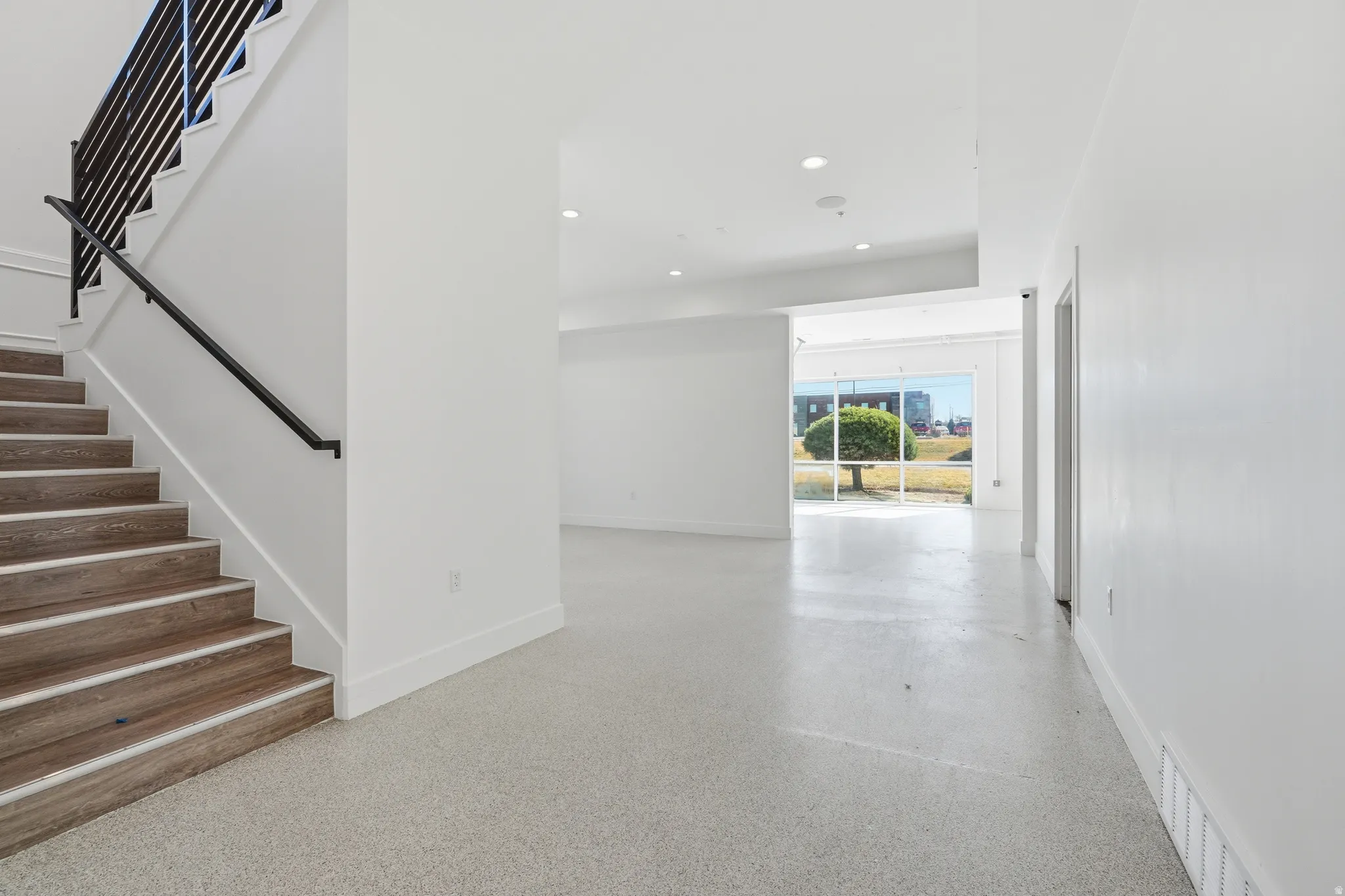 Stairway featuring speckle patterned floor and recessed lighting