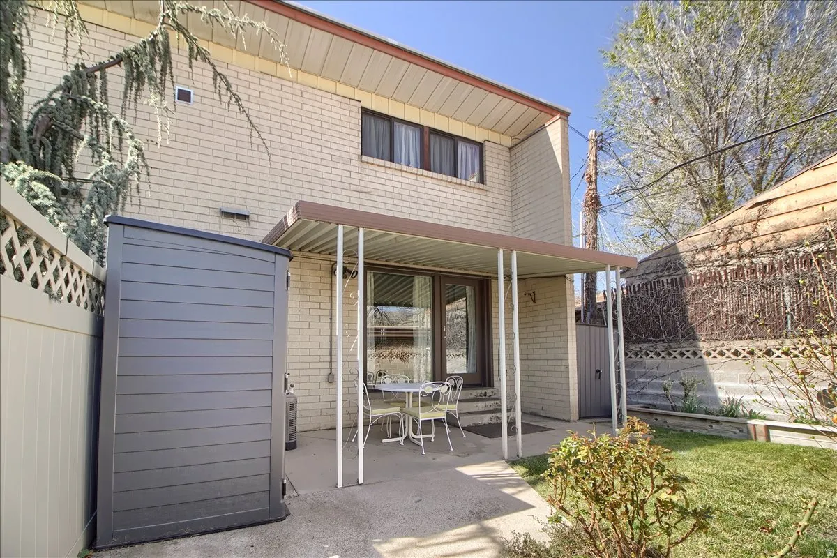 Rear view of house with brick siding and a patio area
