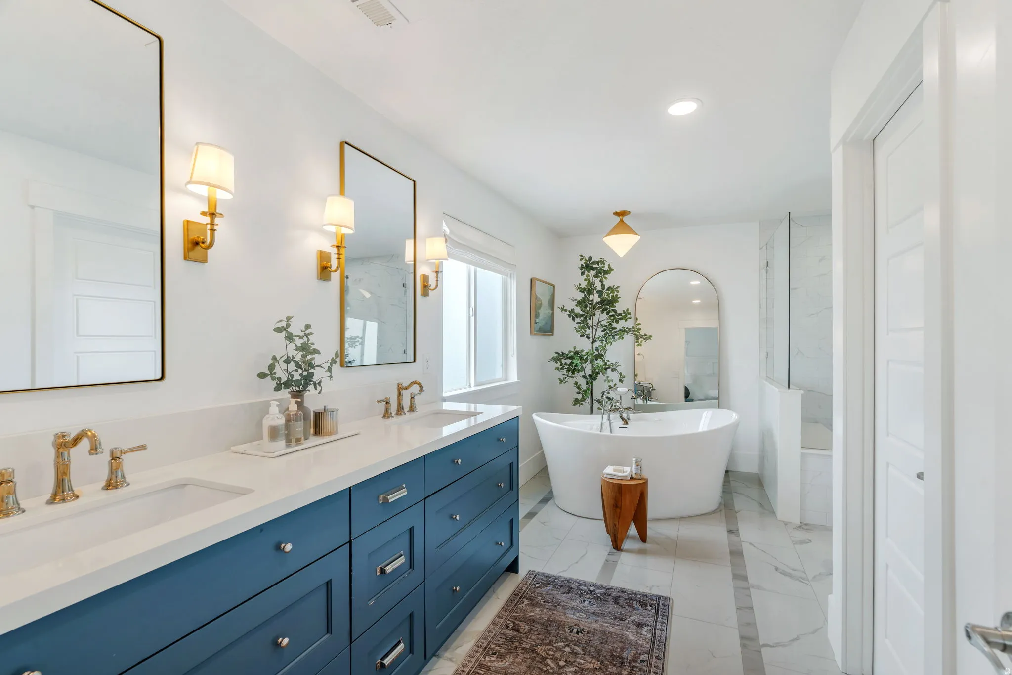 Bathroom featuring double vanity, a soaking tub, and recessed lighting